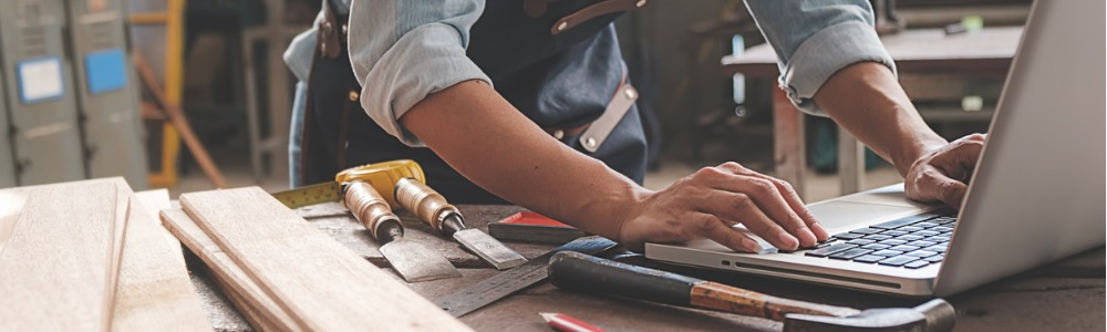 hombre carpintero emprendedor escribiendo en computador portatil