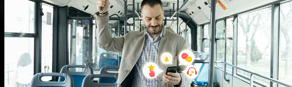 hombre viaja en autobus mientras revisa aplicaciones en su celular
