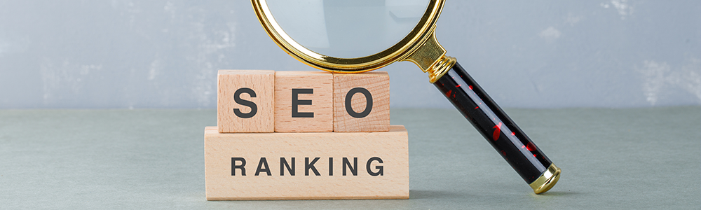 lupa sobre cubos de madera marcados con palabras seo marketing